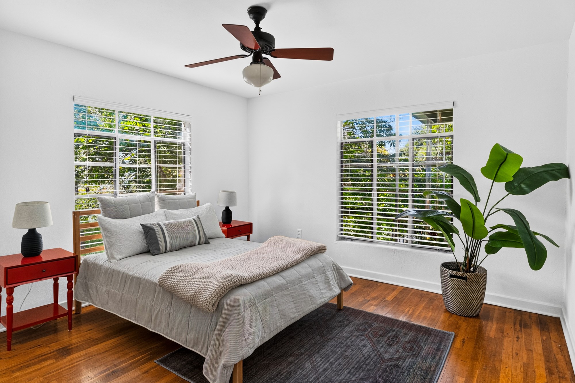 1302 Kirkwood Road, Unit B Austin, TX 78722 - Photo 9 of 21 Hardwood flooring and dual sun-filled windows create an inviting bedroom sanctuary.