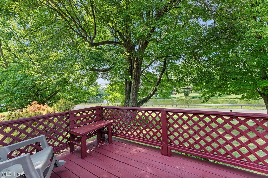 7000 Navarre Road Southwest Massillon, OH 44646 - Photo 6 of 22 Outdoor deck with a red finish and lattice railing, featuring an integrated bench