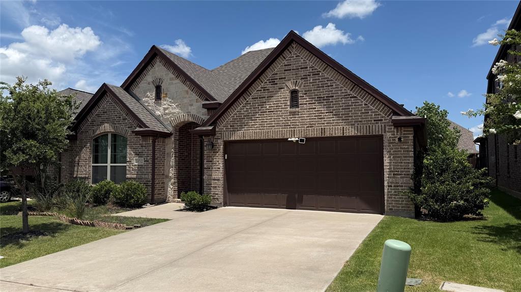 14712 Spitfire Trail Fort Worth, TX 76262 - Photo 1 of 25 Brick and stone facade featuring an arched entryway and a two-car garage
