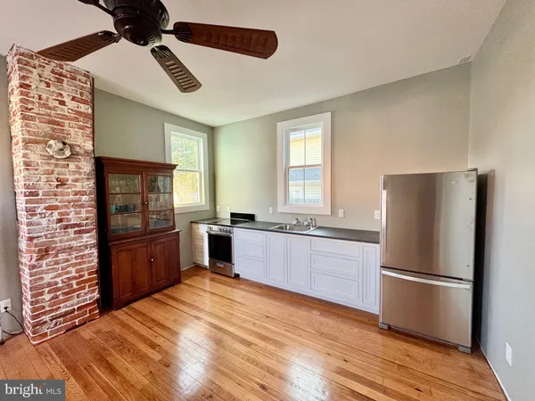 a kitchen with stainless steel appliances a refrigerator and wooden floor