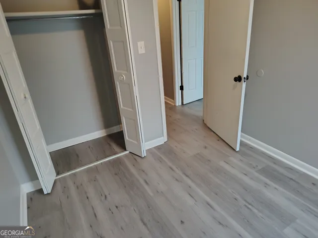 an empty room with wooden floor and entrance