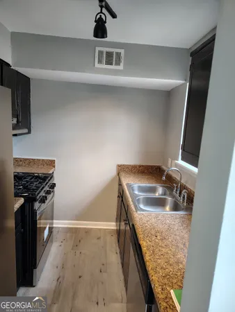 a kitchen with stainless steel appliances granite countertop a sink stove and refrigerator