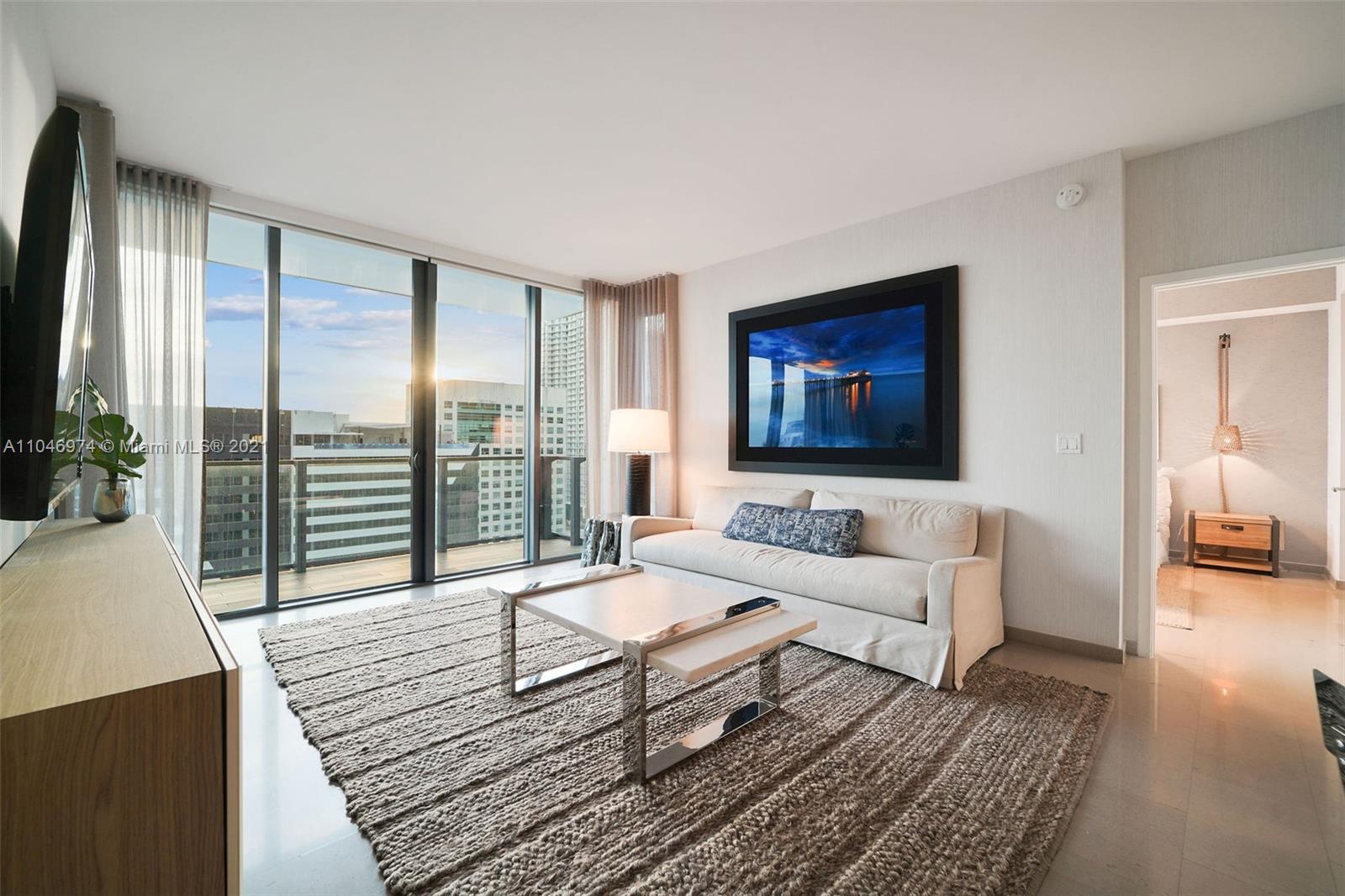 88 Southwest 7th Street, Unit 1904 Miami, FL 33130 - Photo 12 of 28 a living room with furniture large window and a flat screen tv