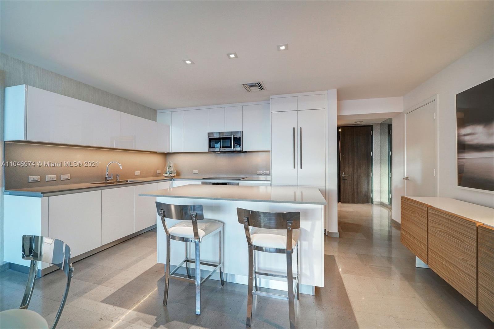 88 Southwest 7th Street, Unit 1904 Miami, FL 33130 - Photo 14 of 28 a kitchen with a table chairs sink and cabinets
