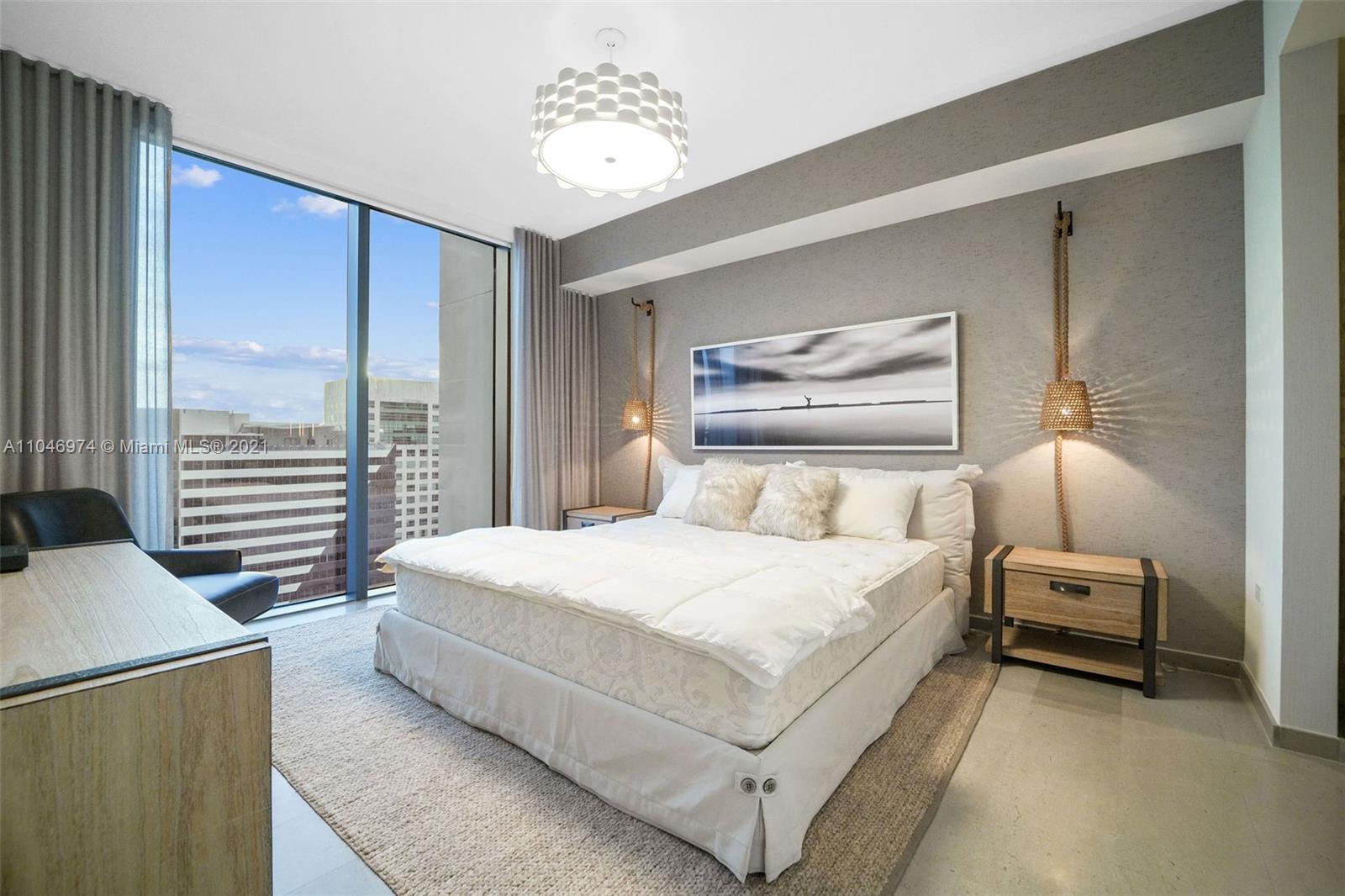 88 Southwest 7th Street, Unit 1904 Miami, FL 33130 - Photo 18 of 28 a bedroom with a large bed and a chandelier