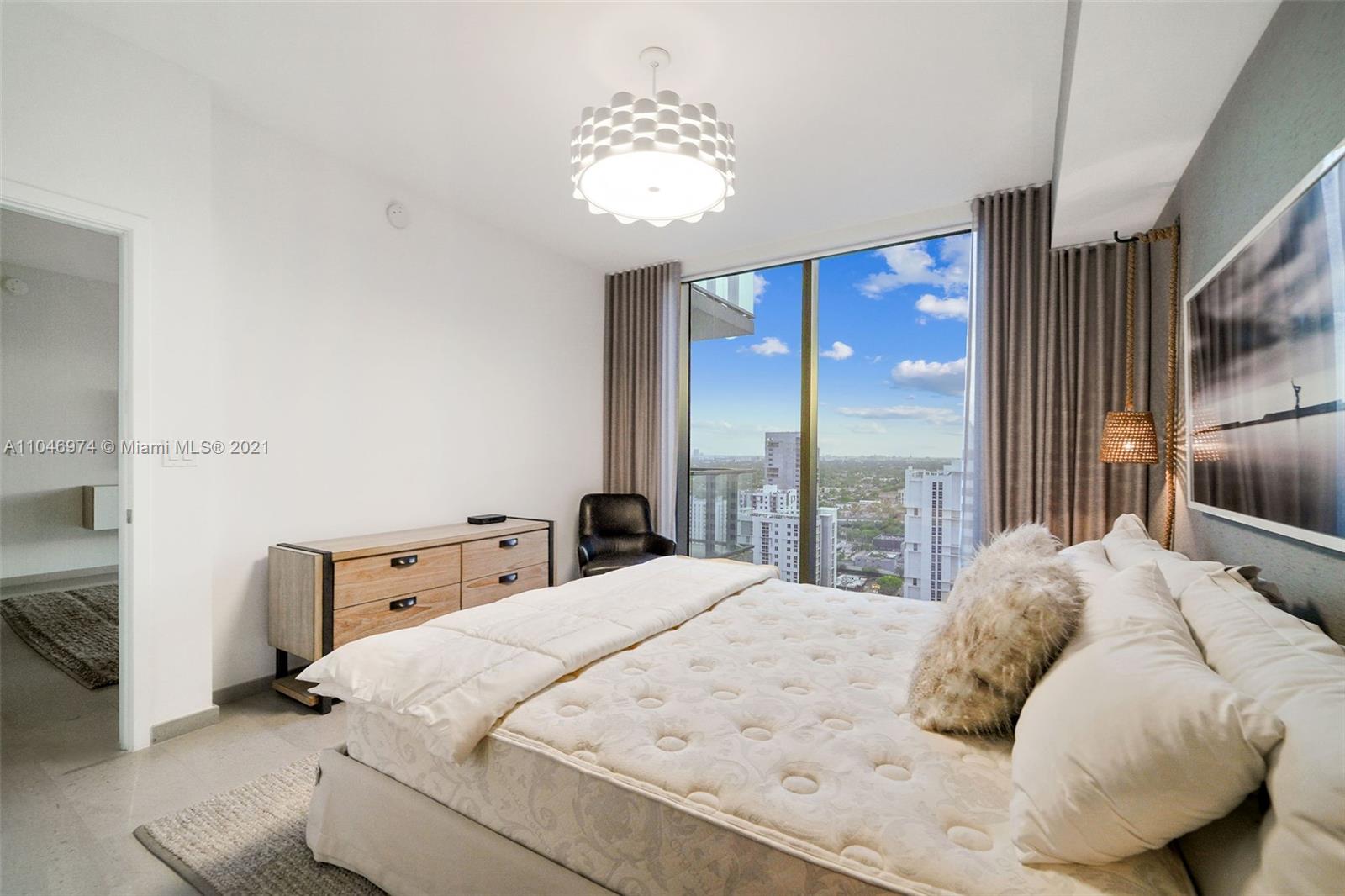 88 Southwest 7th Street, Unit 1904 Miami, FL 33130 - Photo 19 of 28 a large bed sitting in a bedroom next to a window