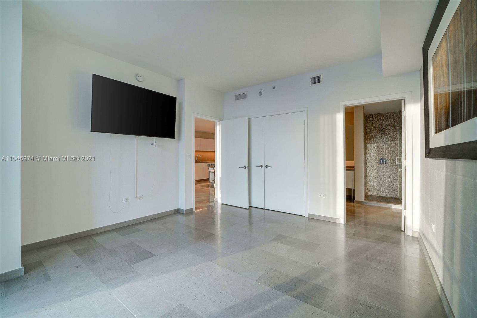 88 Southwest 7th Street, Unit 1904 Miami, FL 33130 - Photo 25 of 28 an empty room with closet and a flat screen tv
