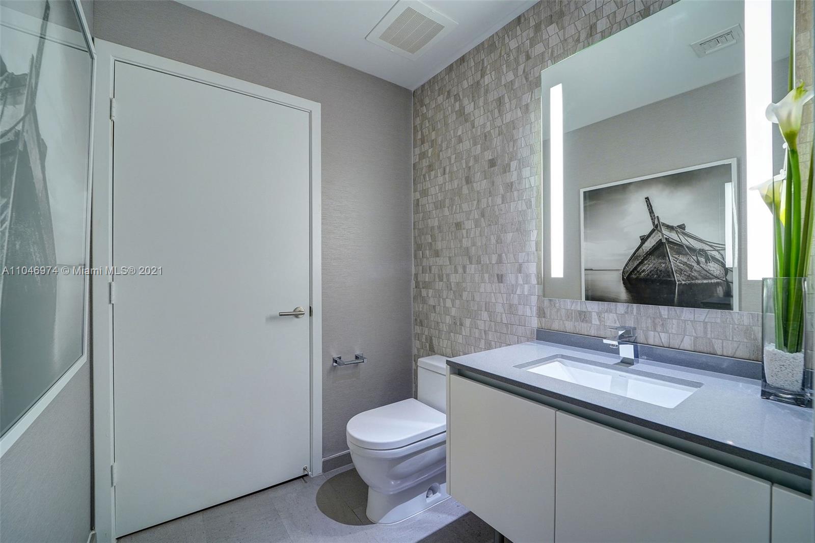 88 Southwest 7th Street, Unit 1904 Miami, FL 33130 - Photo 28 of 28 a bathroom with a granite countertop sink a toilet and a mirror