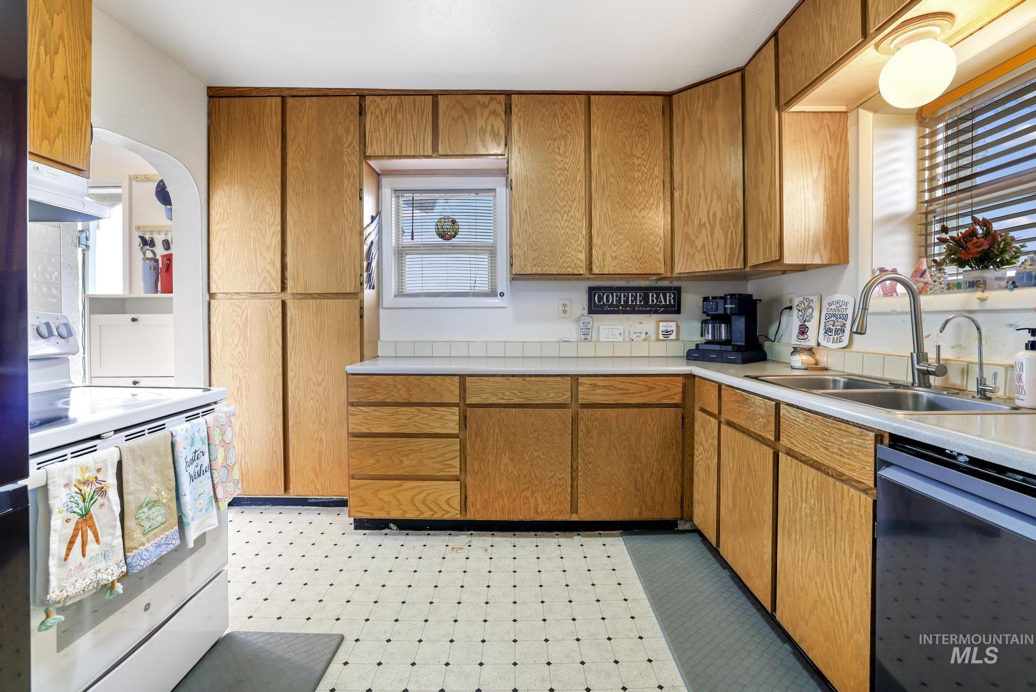 88 South 400 Road West Jerome, ID 83338 - Photo 13 of 31 Kitchen featuring white range with electric cooktop, wood finish cabinets, light floors, and dishwasher