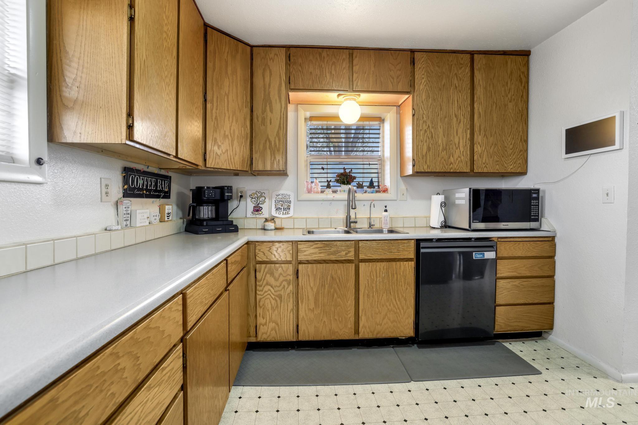 88 South 400 Road West Jerome, ID 83338 - Photo 16 of 31 Kitchen with wood finish cabinets, light floors, dishwashing machine, light countertops, and stainless steel microwave