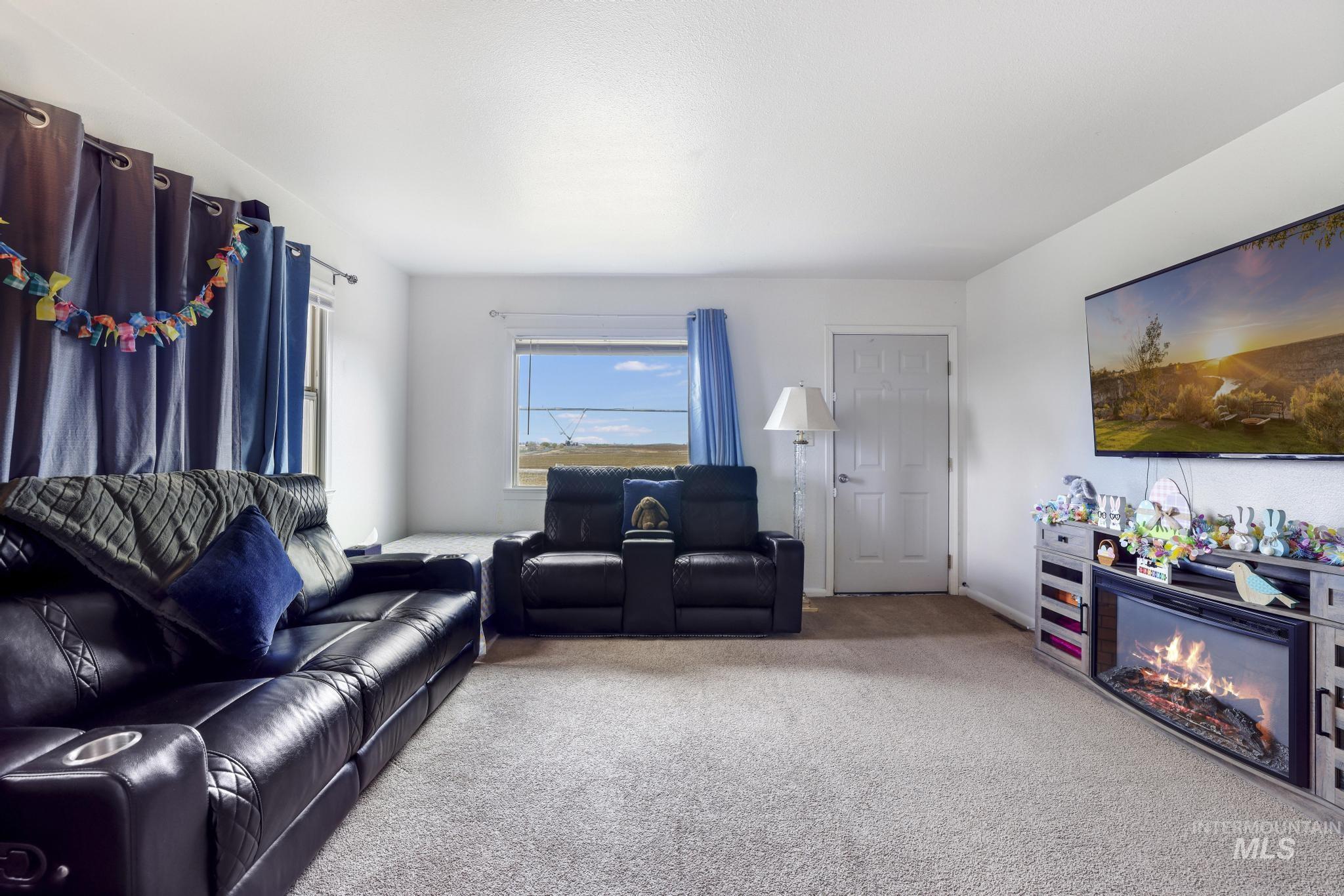 88 South 400 Road West Jerome, ID 83338 - Photo 9 of 31 Living area featuring light carpet and a glass covered fireplace