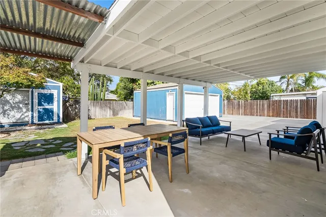 a view of a patio with a table chairs and a barbeque
