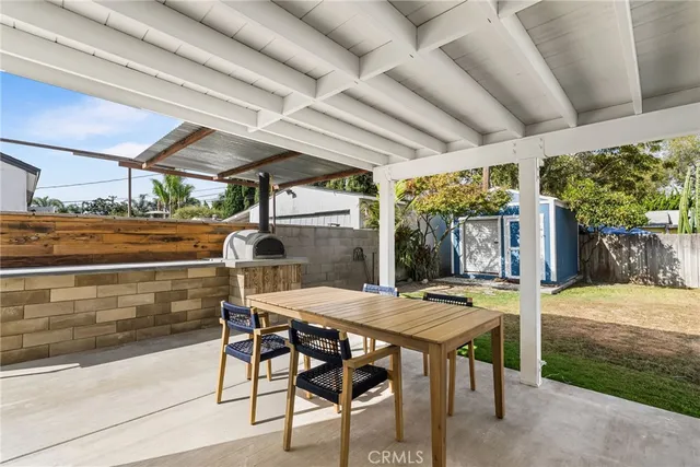 a view of a patio with table and chairs potted plants with wooden floor and fence