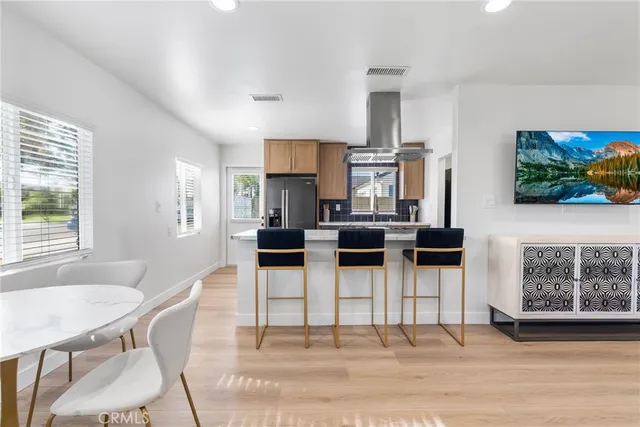 a kitchen with stainless steel appliances kitchen island granite countertop a table and chairs in it