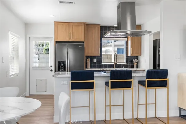 a kitchen with stainless steel appliances kitchen island granite countertop a table and chairs