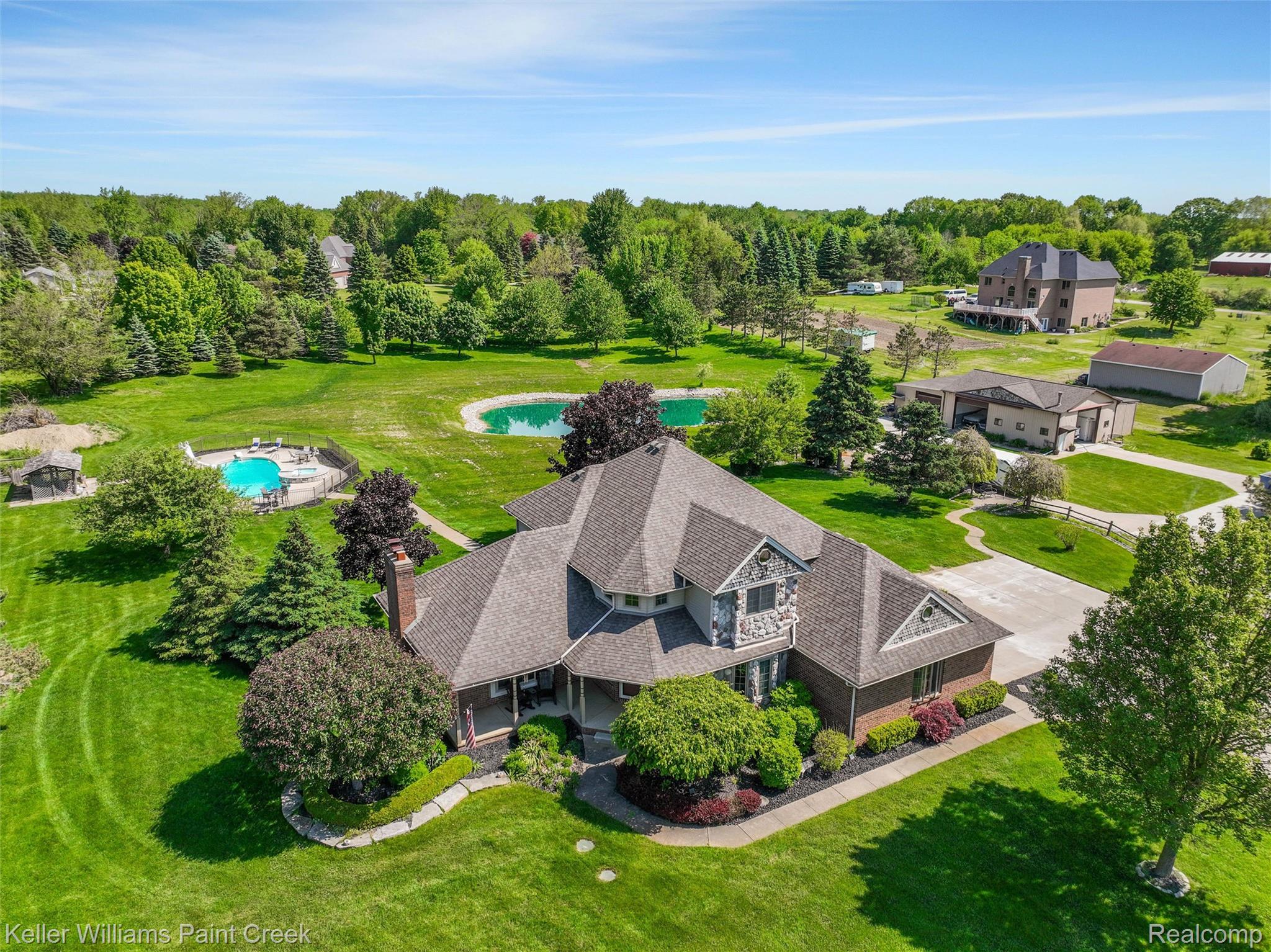 5813 36 Mile Road Romeo, MI 48065 - Photo 75 of 81 Expansive property featuring a large residence with a multi-gabled roof, an inground swimming pool, a pond, and detached outbuildings