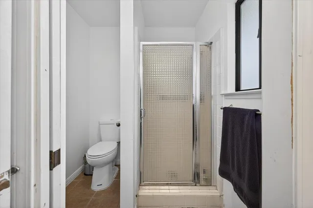 a spacious bedroom with a bed a couch and a chandelier