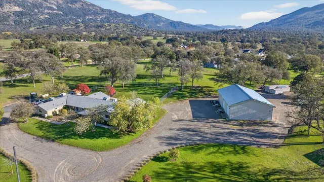 an aerial view of a house with a garden and lake view