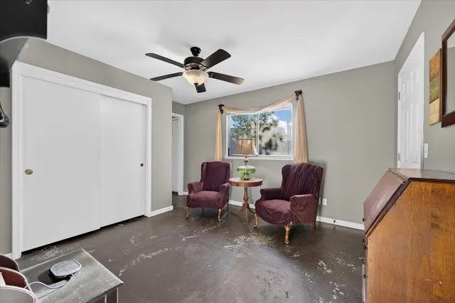 a view of a workspace with furniture and a fan