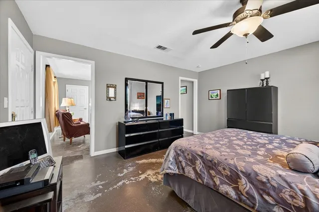 a spacious bedroom with a large bed and a chandelier