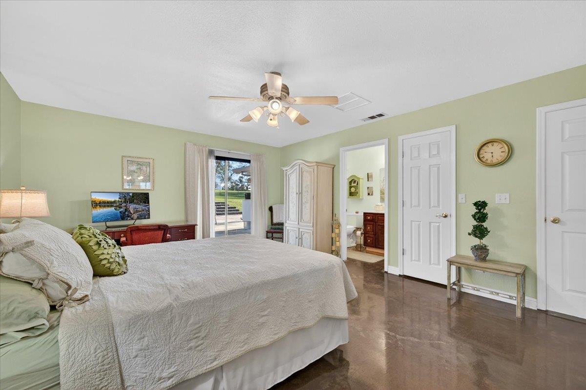 35102 Quail Oak Road Auberry, CA 93602 - Photo 48 of 61 a spacious bedroom with a large bed and a chandelier
