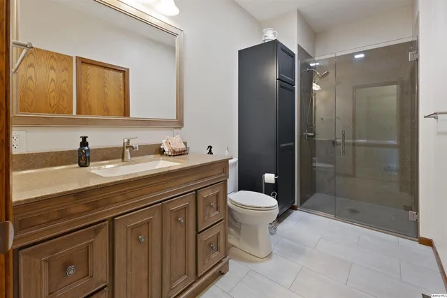 a bathroom with a double vanity sink toilet and shower