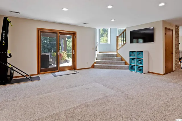 a view of an empty room with a window and a kitchen