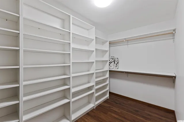 a view of a livingroom with wooden floor and a ceiling fan