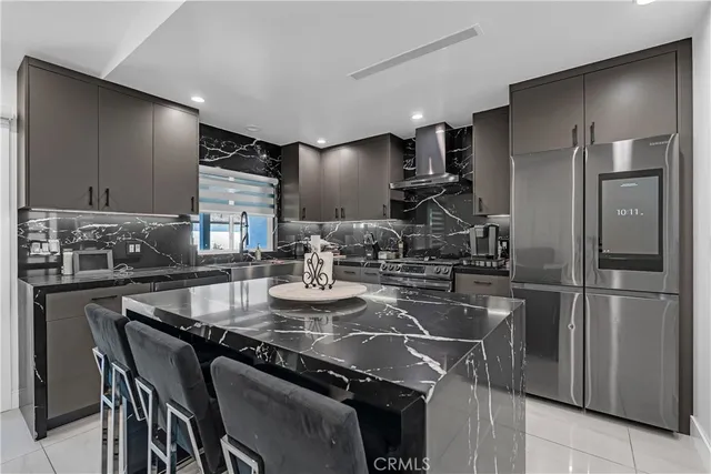 a kitchen with refrigerator and chairs