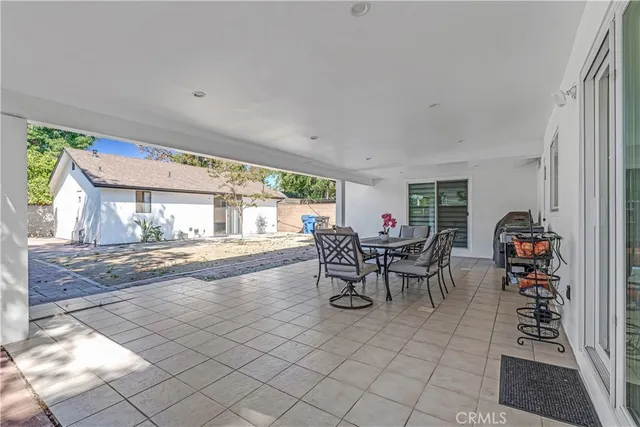a dining room with furniture and a floor to ceiling window