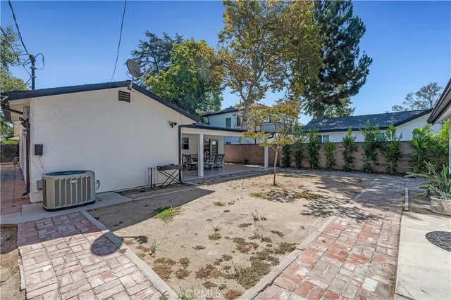 a view of a backyard with a barbeque and wooden fence