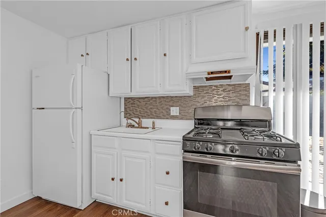 a white stove top oven sitting inside of a kitchen