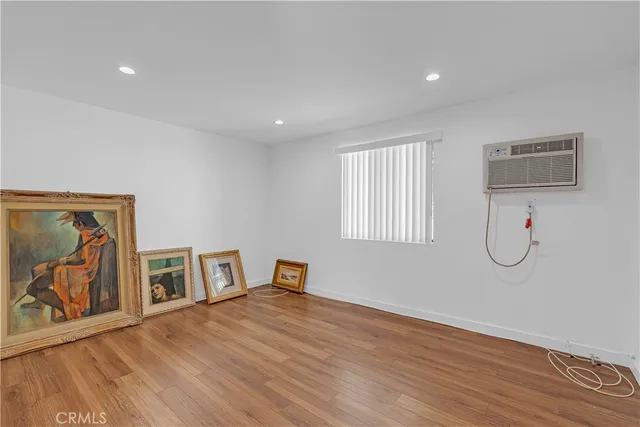 a view of empty room with window and wooden floor