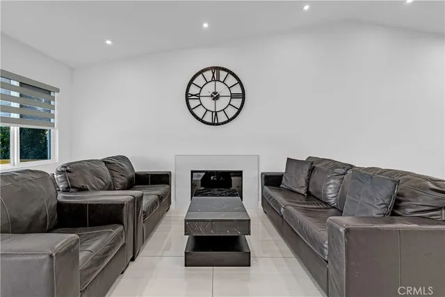 a living room with furniture a clock and a fireplace