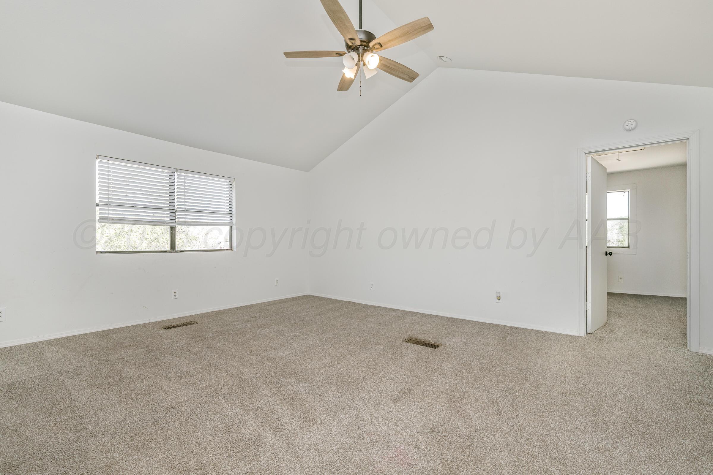 910 8th Avenue Canyon, TX 79015 - Photo 14 of 22 an empty room with windows and fan