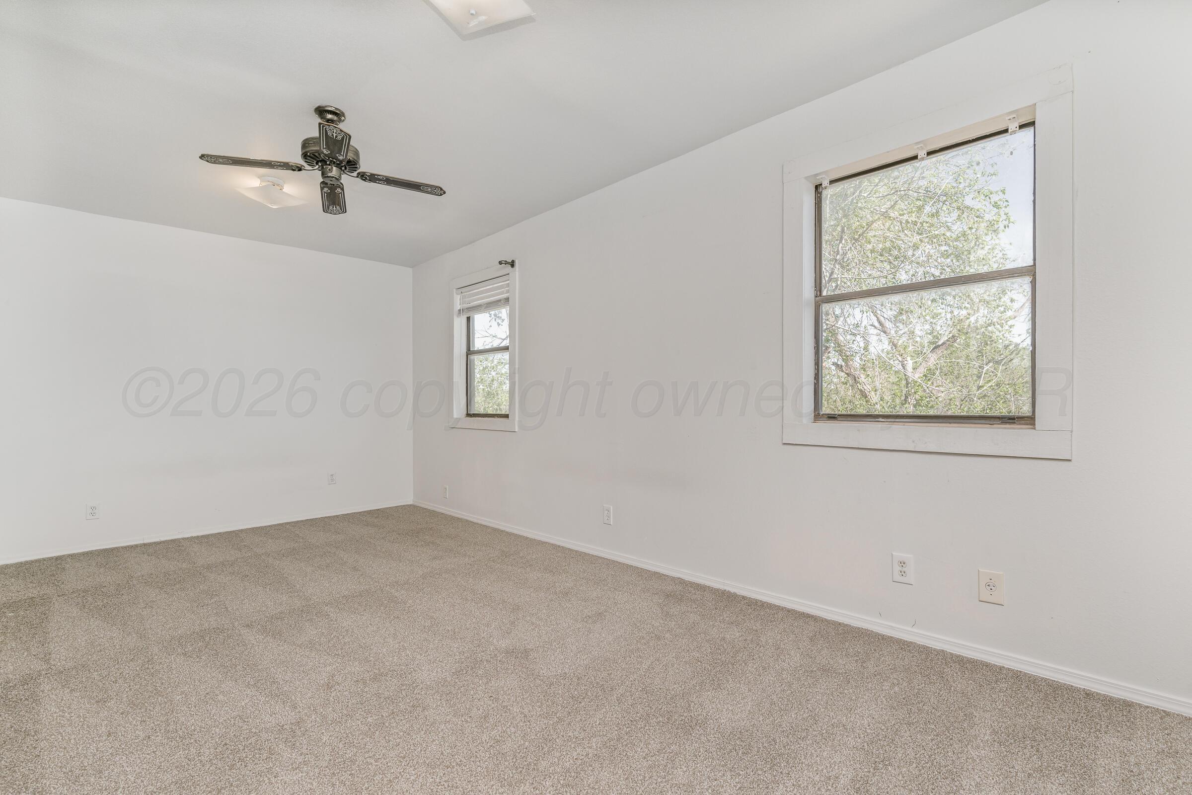910 8th Avenue Canyon, TX 79015 - Photo 19 of 22 an empty room with windows and fan