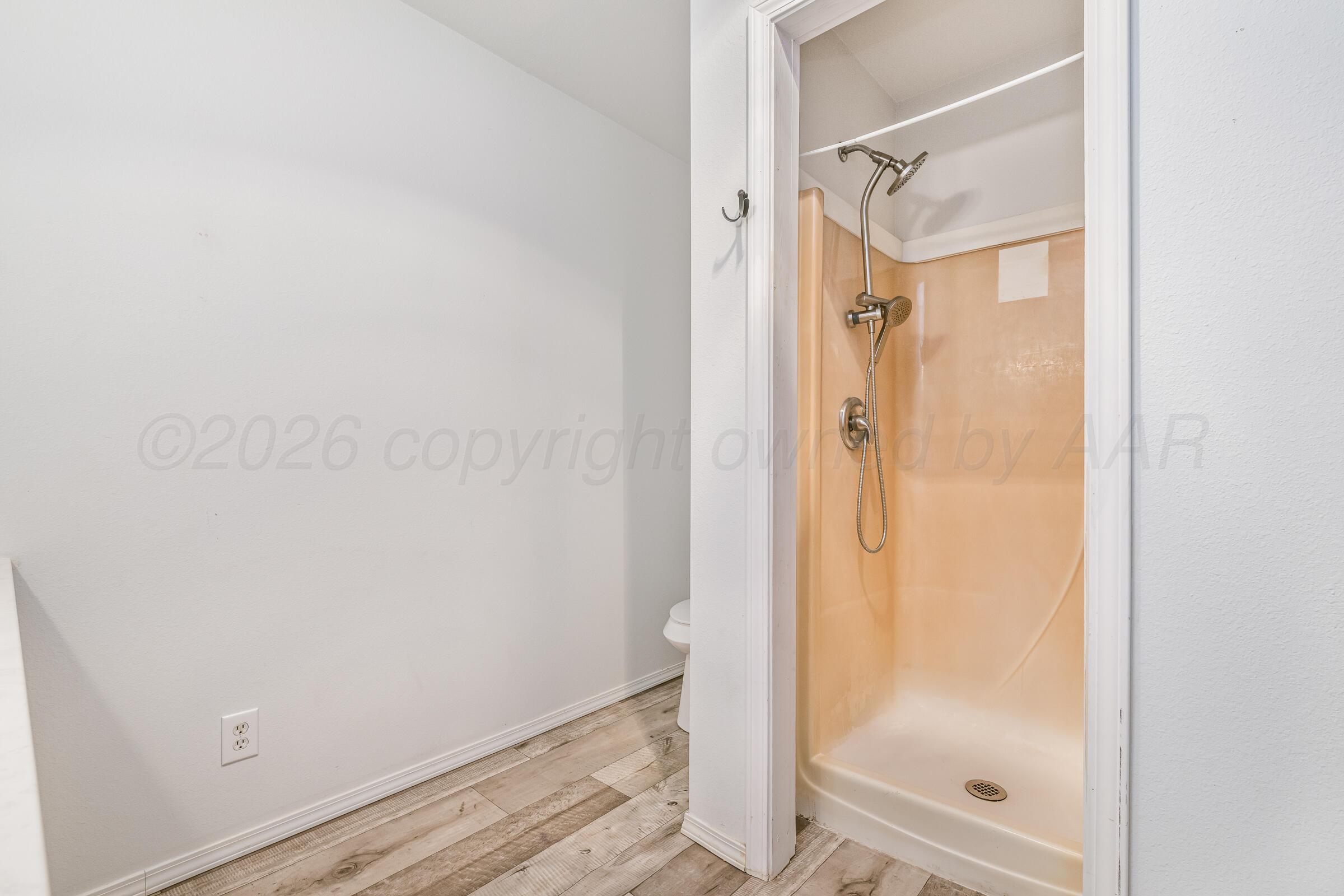 910 8th Avenue Canyon, TX 79015 - Photo 22 of 22 a bathroom with a glass shower door and a mirror