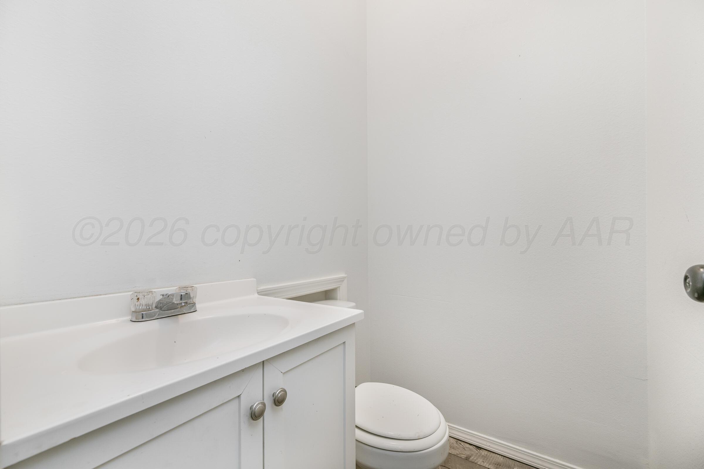 910 8th Avenue Canyon, TX 79015 - Photo 9 of 22 a bathroom with a sink a toilet and vanity