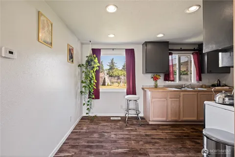 a living room with kitchen island furniture a potted plant and a kitchen view
