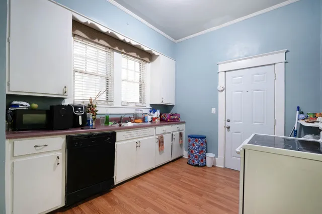 an empty room with wooden floor closet and windows