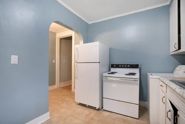 a view of a patio with table and chairs and potted plants and large trees