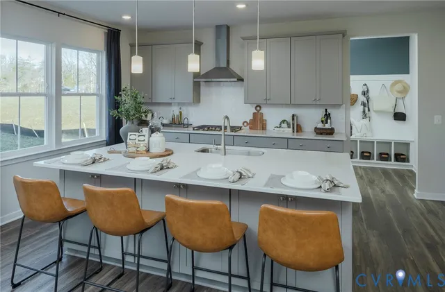 a kitchen with stainless steel appliances granite countertop a table chairs sink and cabinets