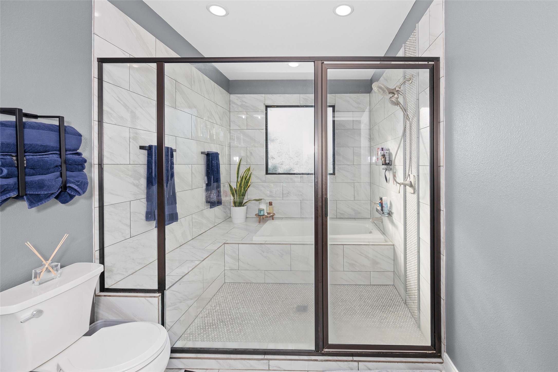 2021 Strangmeier Road Brenham, TX 77833 - Photo 12 of 16 Step into your own spa inspired bath that showcases a stunning oversized walk-in shower and soaking tub combination, with beautifully finished floor to ceiling marble-look tile and dark- framed glass enclosure