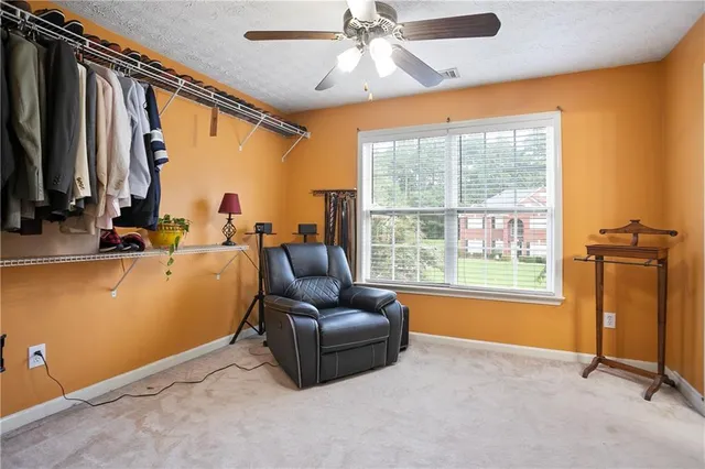 a spacious bedroom with a bed a dresser and large windows