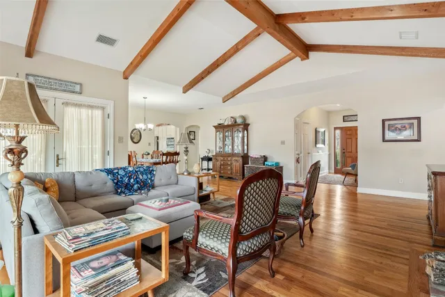 a living room with furniture a wooden floor and a chandelier