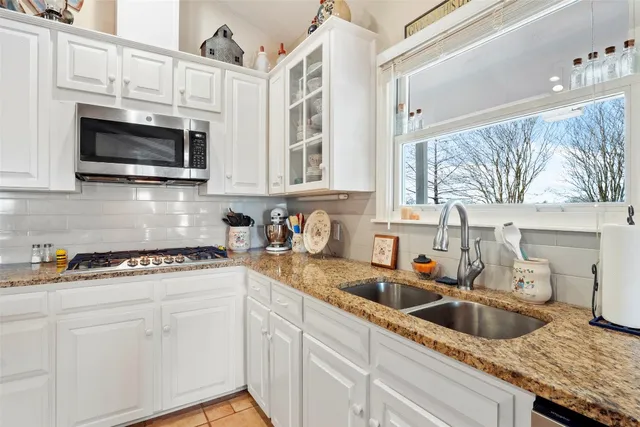 a kitchen with stainless steel appliances granite countertop a sink and a stove