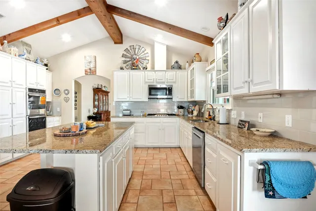 a kitchen with stainless steel appliances a refrigerator sink and cabinets