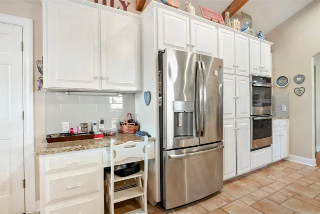 a kitchen with cabinets and chairs