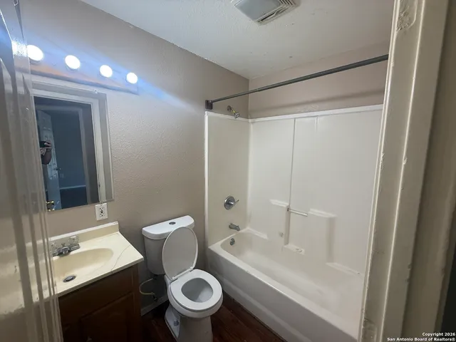 a view of an empty room with glass door and a bathroom