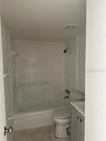 a bathroom with a granite countertop toilet a sink and shower